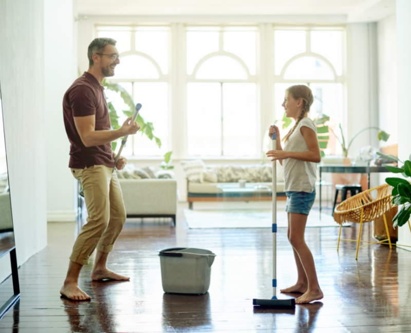 father and daughter having fun while spring cleaning