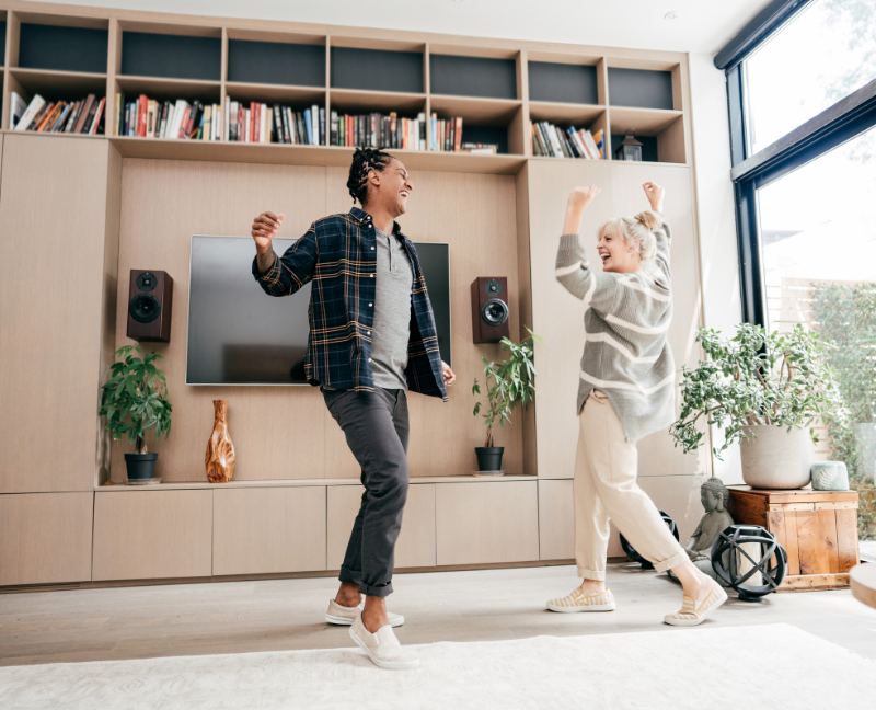 couple dancing in living room with bookshelf