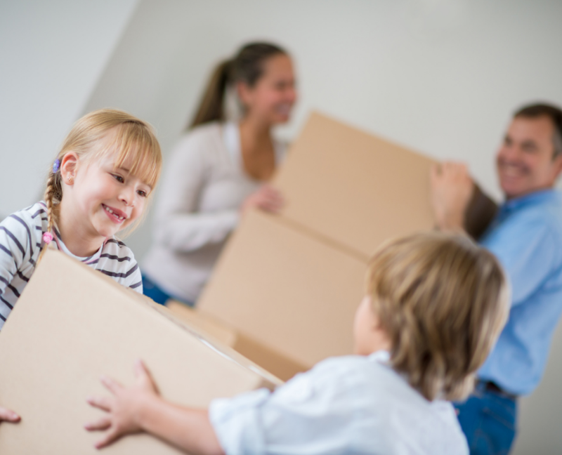 kids helping parents carry boxes at new house