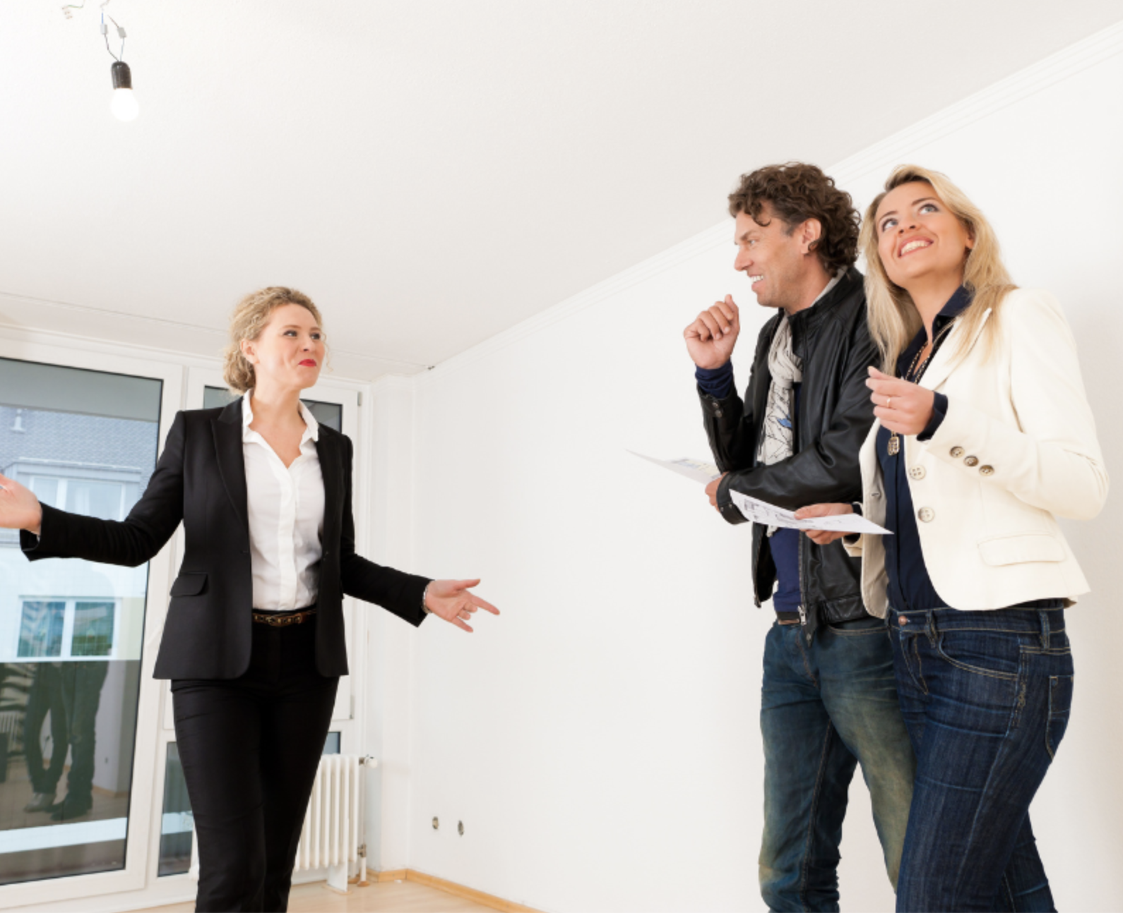 real estate agent showing house to couple home buyers