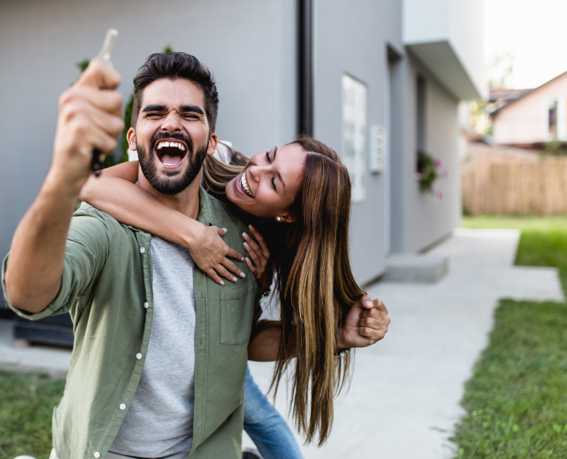 happy couple holding a key after buying a home