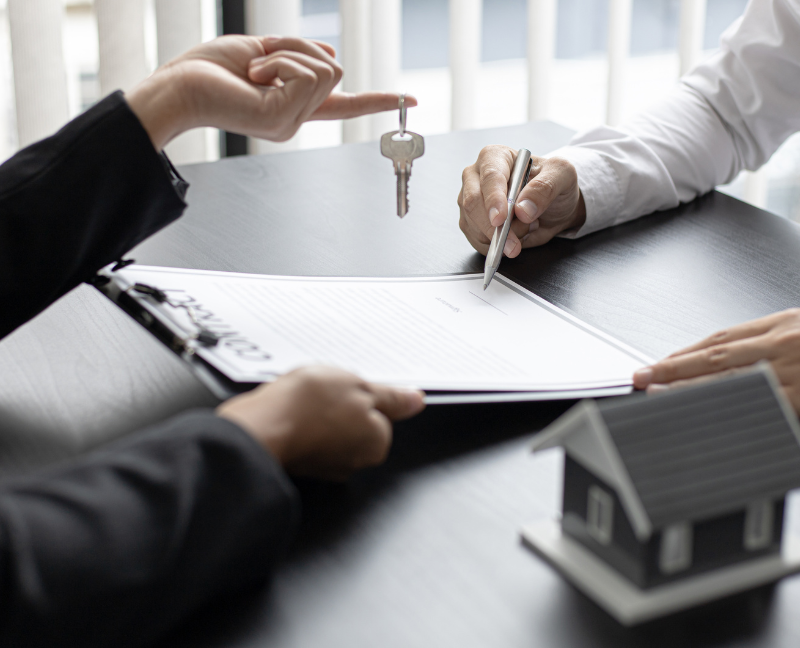 real estate agent signing contract and giving key
