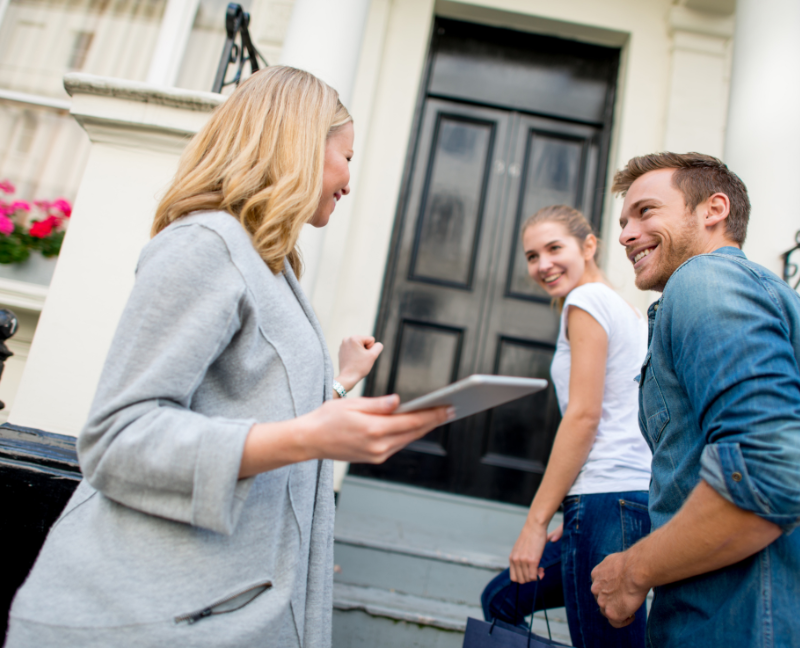 real estate agent talking to couple buying home