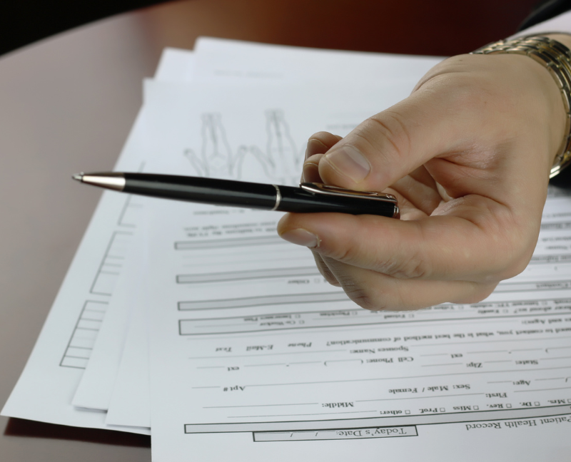 hand holding pen signing mortgage contract