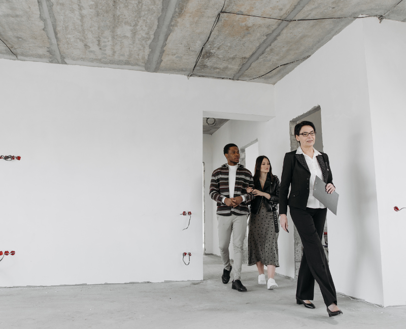 husband and wife touring new house with real estate agent