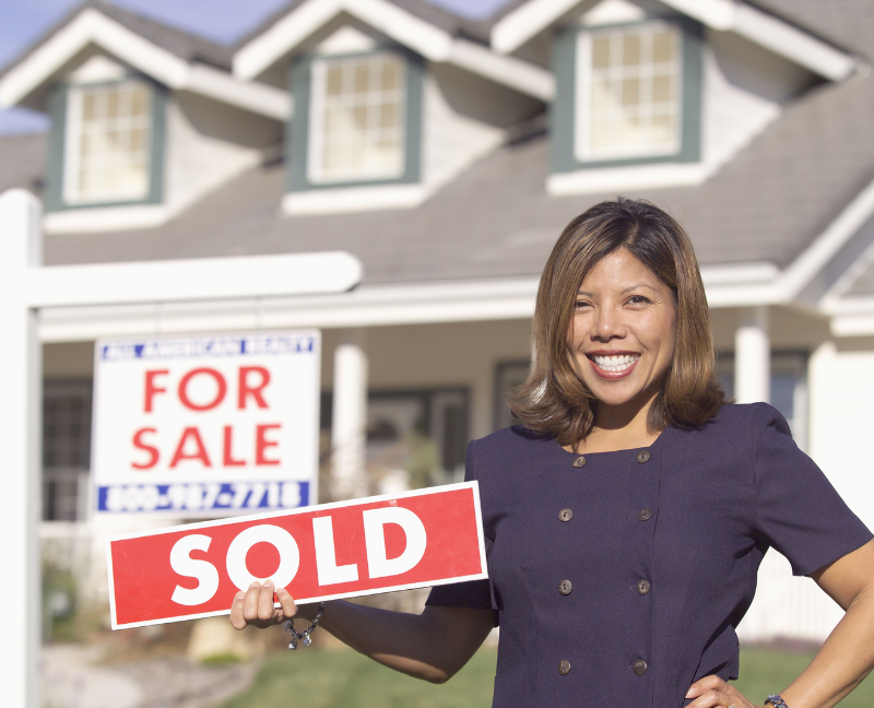 real estate agent holding sold sign
