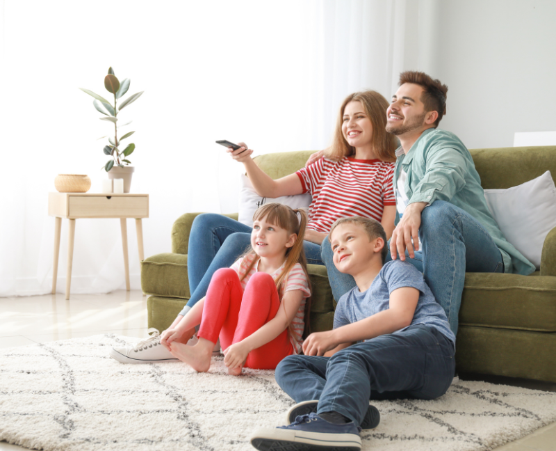 family at living room watching television