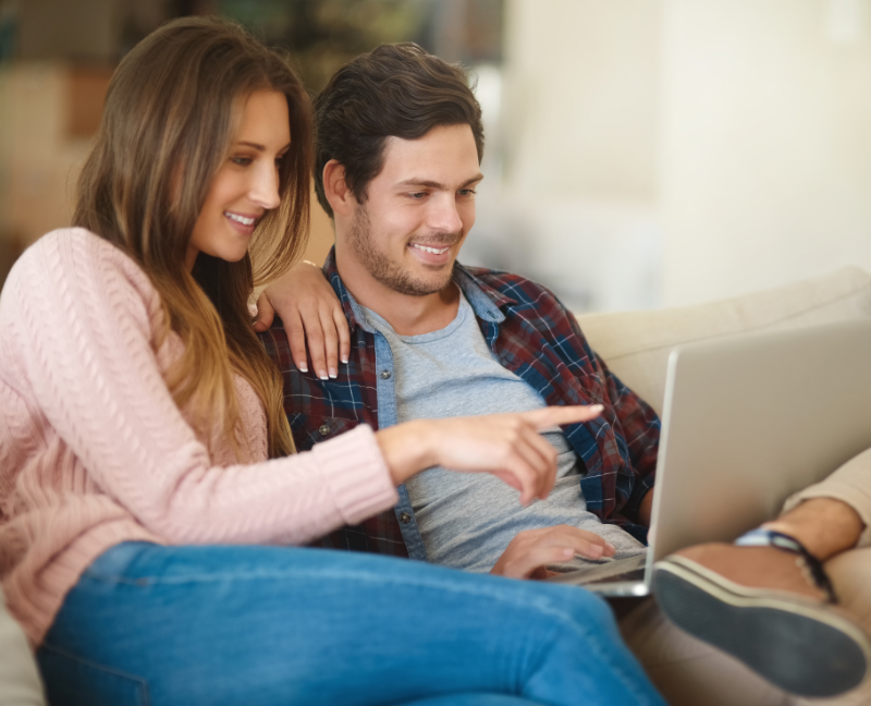 a couple browse real estate online on a laptop